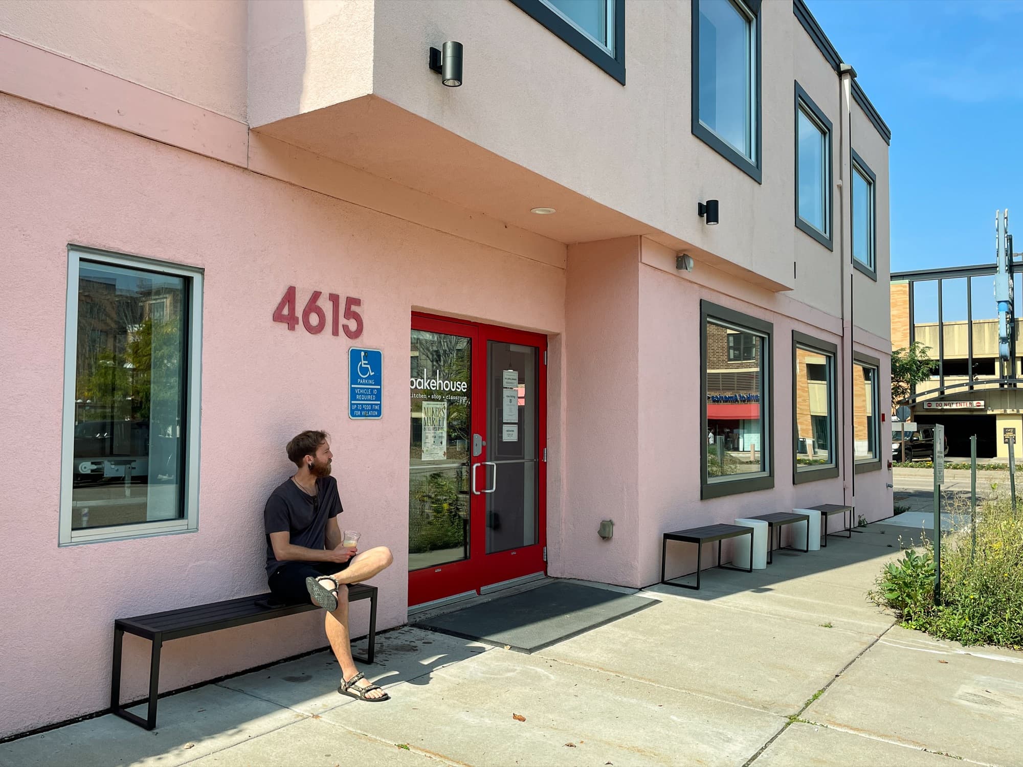 Bakehouse entrance with red double doors and a bench