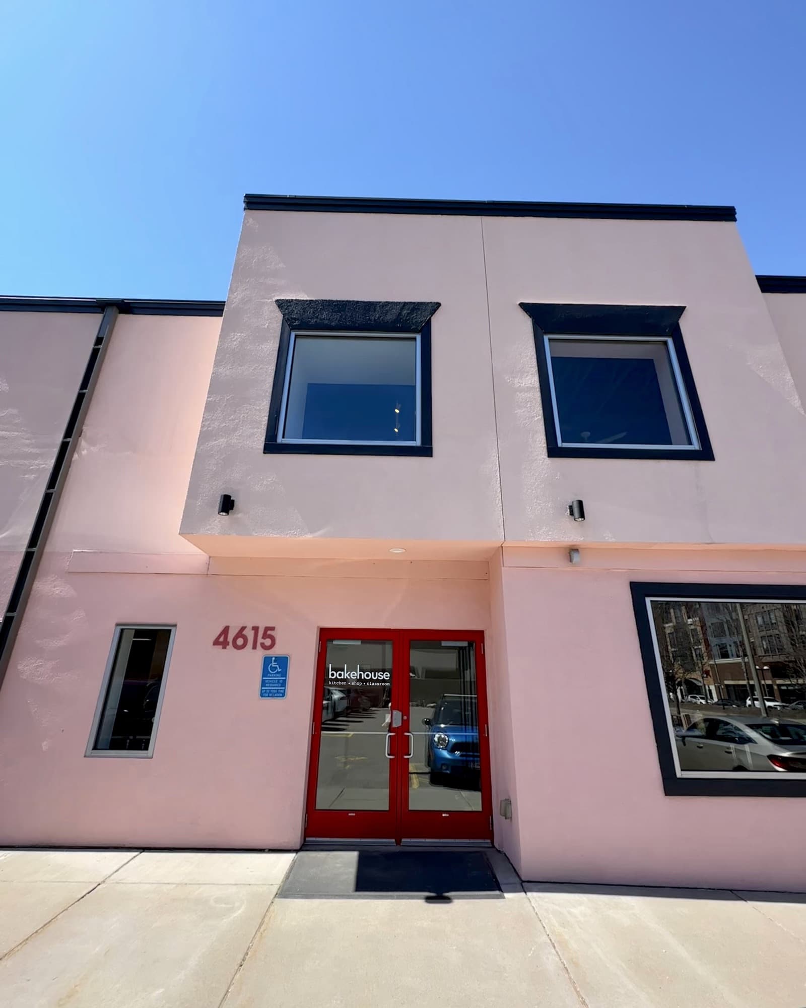 Front of the bakehouse building with red doors under a pink facade