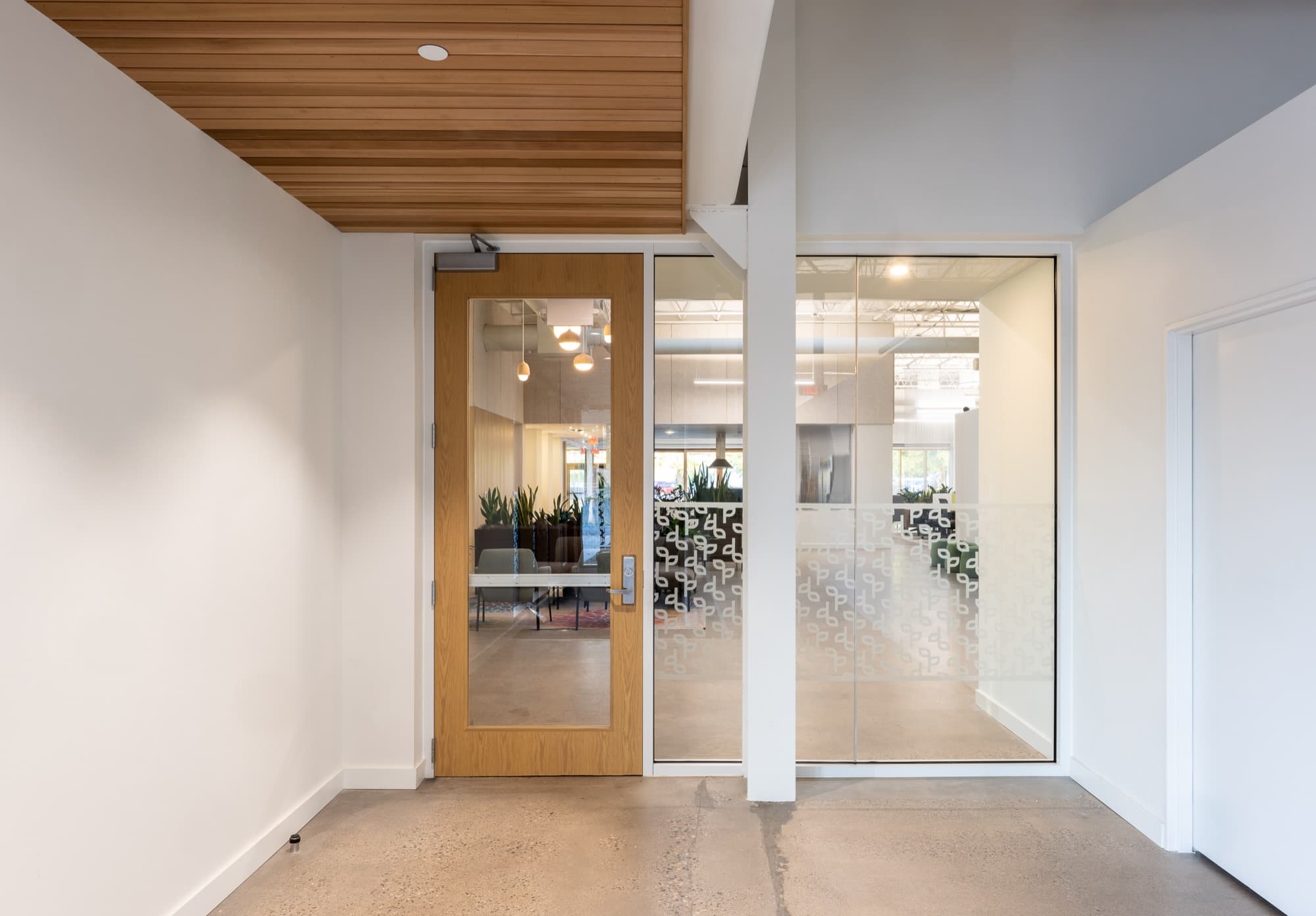 Wood-framed glass door beneath a wood-clad soffit