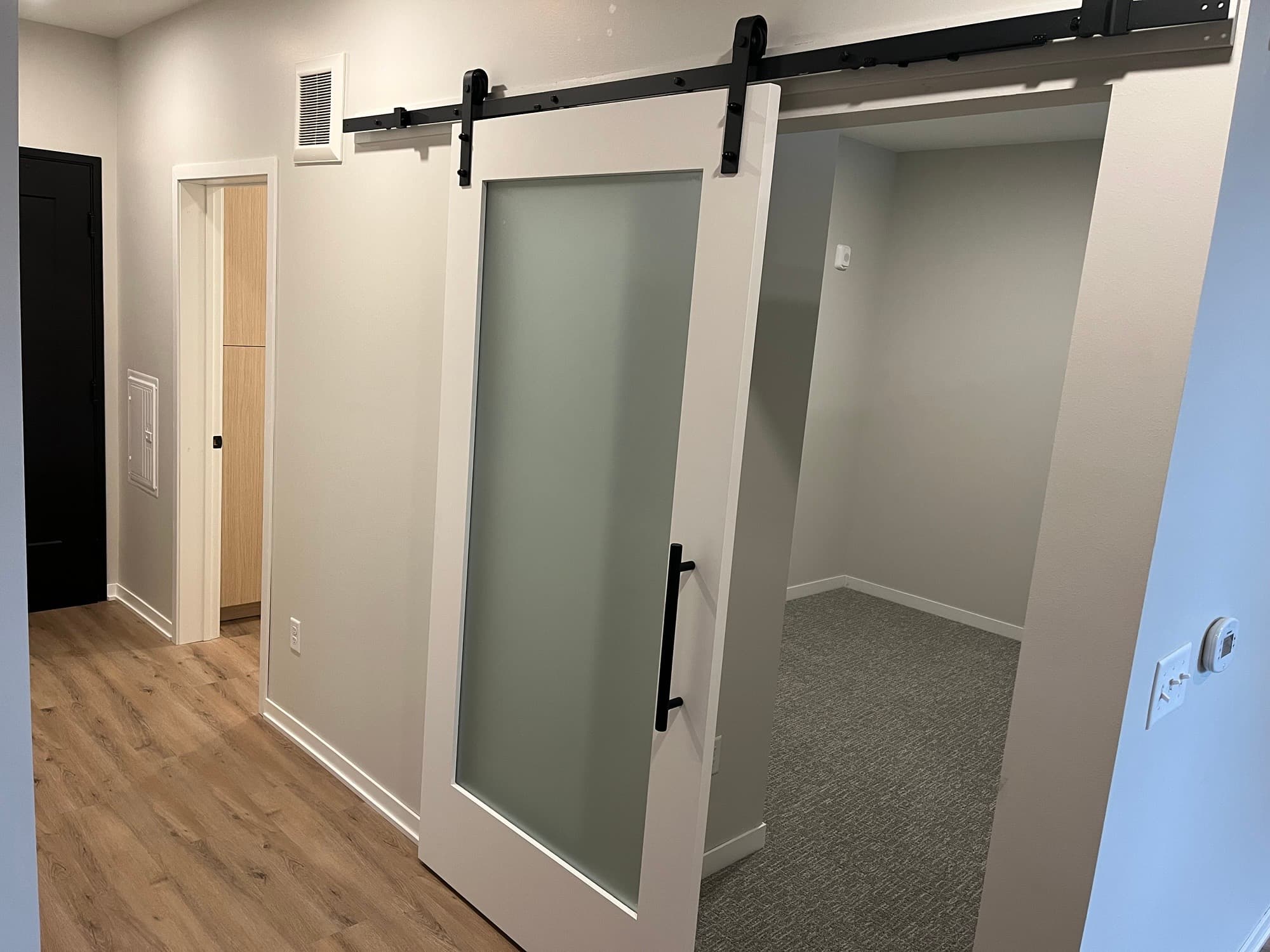 Apartment hallway with a frosted glass barn door