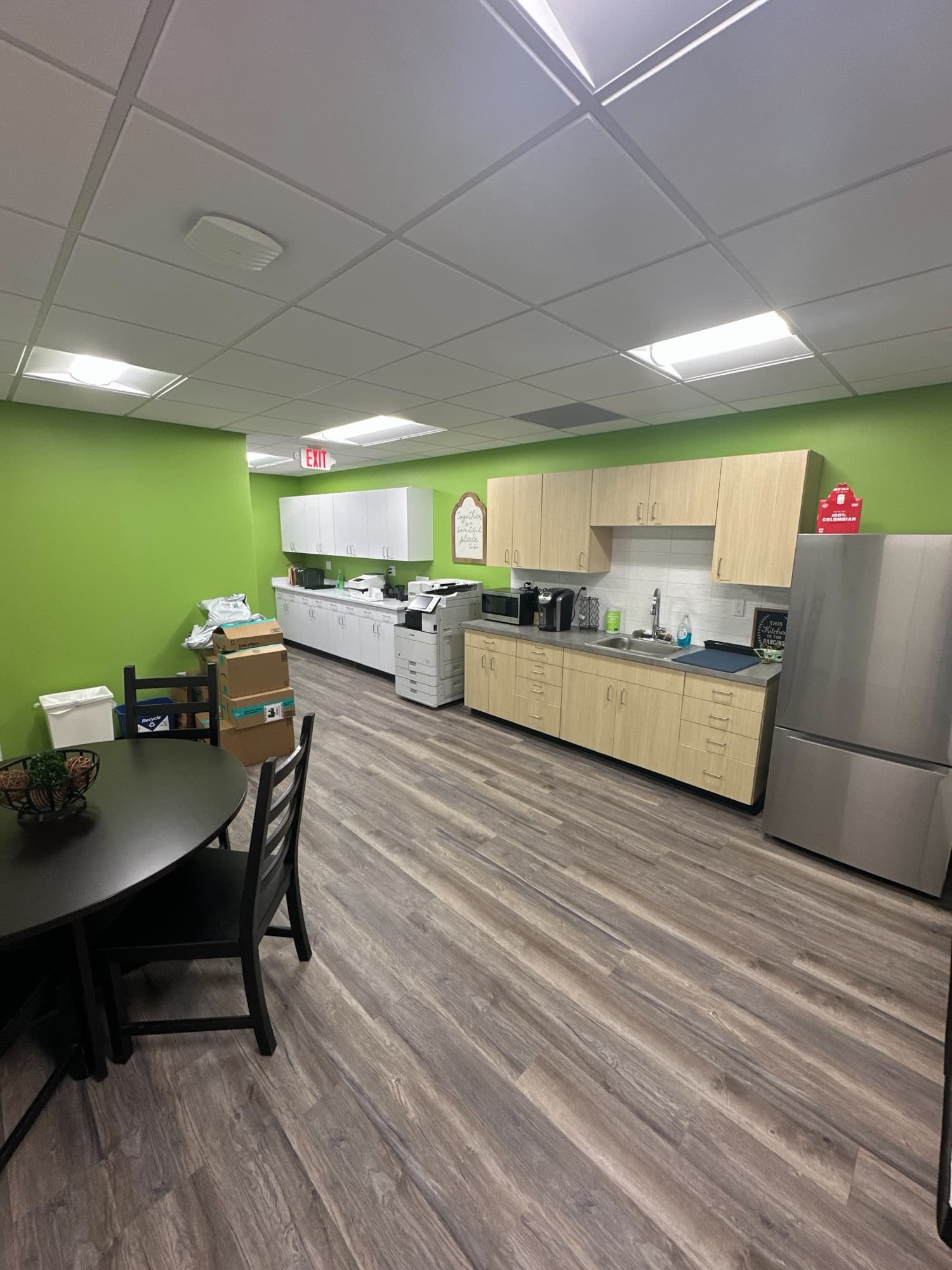 Break room with a kitchenette, dining table and lime green accent wall