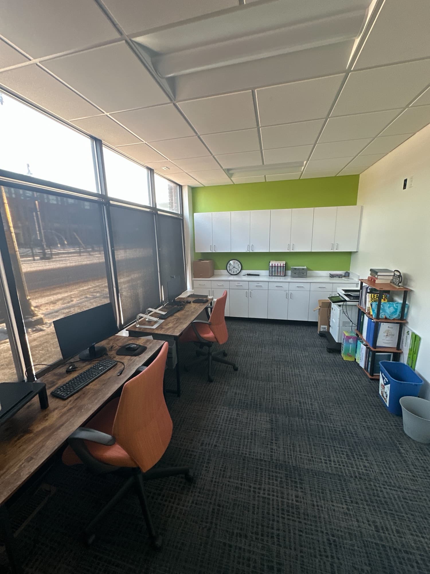 Open workspace with desks along a wall of windows